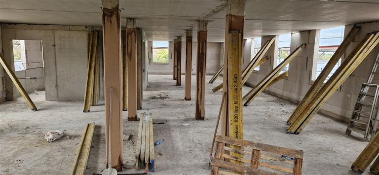 Untersicht einer Betondecke in einem Rohbau, getragen von Stützen und Schrägstreben